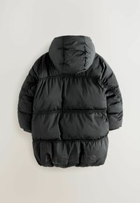 Veste rembourrée noire avec capuche, sections cousues et branding discret. Texture lisse et poignets élastiques complètent le design.