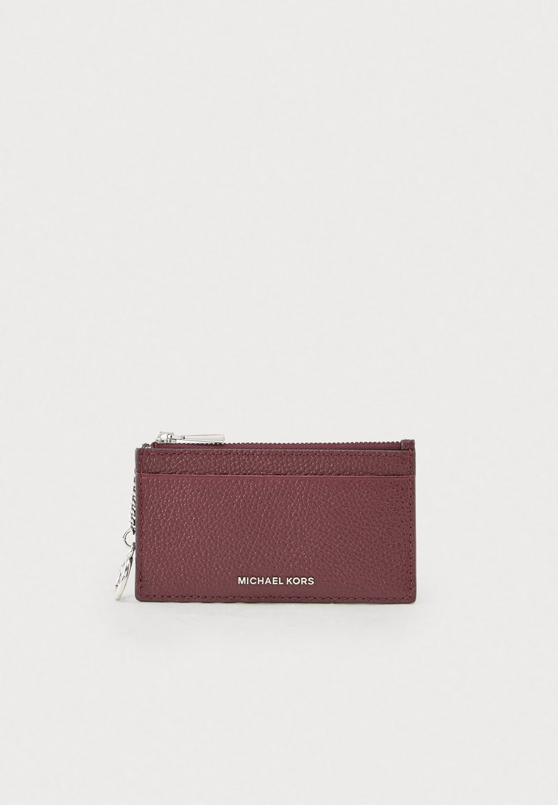 Burgundowa skórzana wizytówka z teksturowanym wykończeniem, z zamkiem błyskawicznym, akcentami w kolorze srebrnym oraz logo "MICHAEL KORS" z przodu.