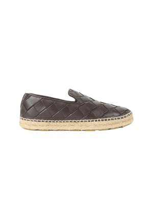 Zapato tipo slip-on de cuero tejido marrón oscuro con suela de esparto natural y suela de goma, vista lateral sobre fondo blanco.