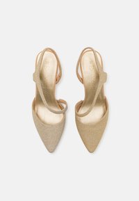 Chaussures à talons hauts dorées et pailletées avec des orteils pointus, des côtés ouverts et des brides autour de la cheville. L'intérieur est d'un doré clair avec des détails en logo en relief.