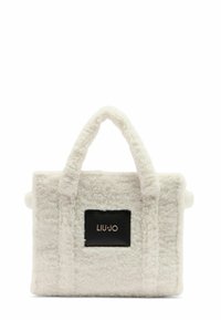 Borsa a tote bianca in peluche con tessuto texture, due manici e una targhetta logo rettangolare nera. Forma quadrata con un aspetto morbido e soffice.