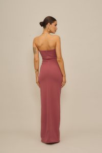 Αμάνικο, εφαρμοστό βραδινό φόρεμα σε απόχρωση σκόνης τριαντάφυλλου, κατασκευασμένο από απαλό ύφασμα. Διαθέτει κρυφό φερμουάρ στην πλάτη και μακρύ, κομψό σιλουέτα.