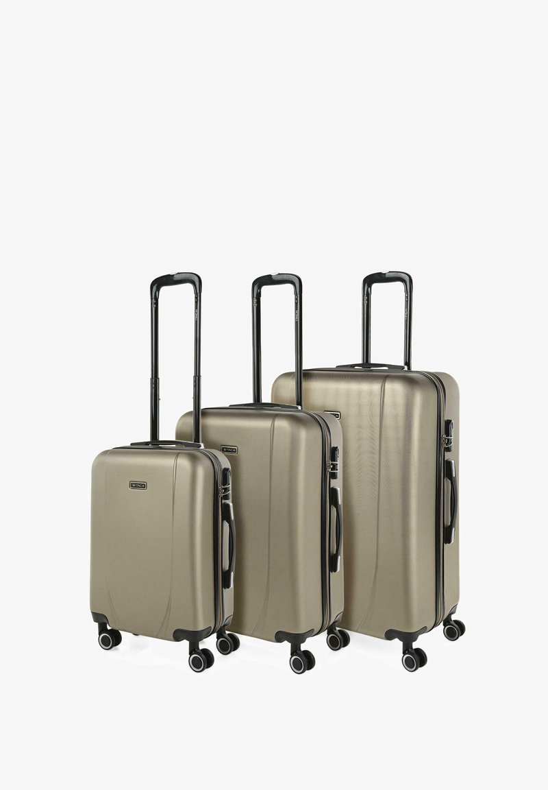 Tres maletas rígidas en color dorado metálico. Textura lisa, asas negras retráctiles, cuatro ruedas, con cremalleras y logo de la marca.