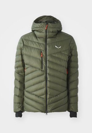 Casaco puffer verde oliva com capuz, apresentando um acolchoado em forma de chevron, fecho negro e puxadores laranja. Inclui buracos para os polegares nas mangas.