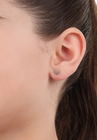 Orecchini a perno a forma di farfalla in argento con accenti di gemme multicolori, caratterizzati da un design simmetrico e una superficie lucida.