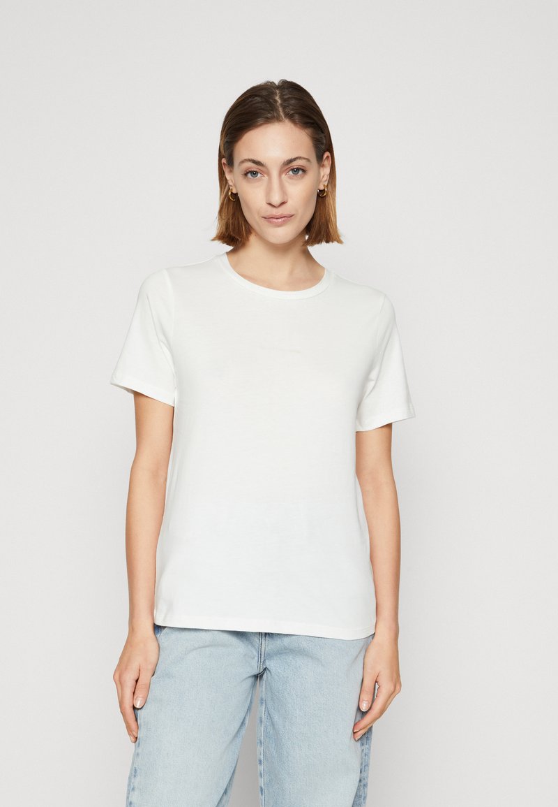 Camiseta de algodón blanca con mangas cortas, cuello redondo y un corte relajado. Presenta una textura suave y un diseño minimalista.