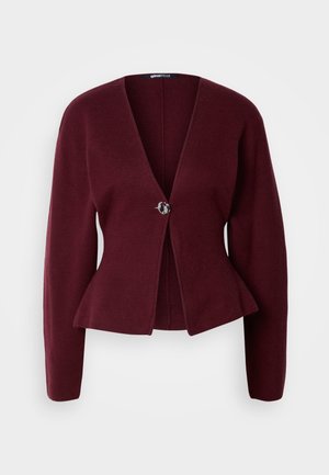Burgundský kardigan s výstřihem ve tvaru V, dlouhými rukávy a peplum spodním lemem. Obsahuje jedno dekorativní knoflíkové zapínání s kontrastním designem. Měkká textura.