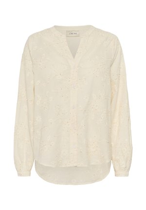 Kremowa bluzka z długim rękawem z haftowanymi kwiatowymi wzorami, zapinana na guziki z przodu, z dekoltem w kształcie litery V i zaokrąglonym dołem.