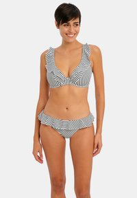 Bikini a righe bianche e nere con scollatura profonda, bordi delle maniche a volant e slip coordinato con dettagli a volant.