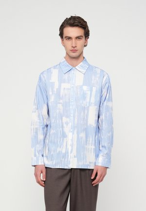 Niebiesko-biała koszula z długim rękawem, z pionowymi paskami i abstrakcyjnym wzorem chmur. Zapięcie na guziki i klasyczny kołnierzyk.