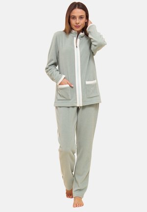 Mintgrünes Fleece-Loungewear-Set mit hohem Kragen, Reißverschluss und zwei Fronttaschen. Kontrastierende weiße Paspelierung und weiche Textur.