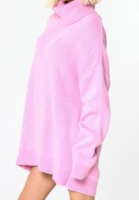 Nadrozměrný růžový rolákový svetr s žebrovanými manžetami a lemem. Má strukturovaný pletený vzor a uvolněný střih.