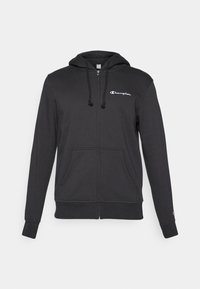 Schwarze Zip-Hoodie aus weichem Stoff mit einer Kordelzugkapuze, Fronttaschen und einem kleinen weißen Logo auf der oberen linken Brust.