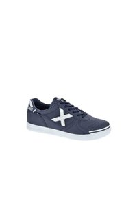 Zapatilla color azul marino con detalles blancos y perforaciones. Presenta un logo de estrella blanca, puntera redonda y una suela de goma texturizada.