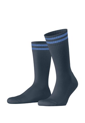Paire de chaussettes bleu foncé montantes avec deux bandes bleu clair près du haut, debout sur un fond blanc.