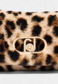 Torebka w leoparda wykonana z pluszowego materiału z złotym zapięciem w formie logo. Charakteryzuje się miękką teksturą oraz ciemnymi i jasnobrązowymi plamkami.
