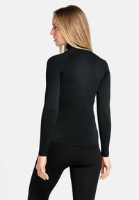 Enganliegendes schwarzes Langarmoberteil mit hohem Kragen, strukturiertem Muster und glattem Stoff. Bietet eine schlanke, moderne Silhouette.