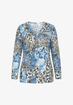 Chemise à manches longues col en V avec motifs floraux bleus, étoiles, tourbillons mélangés et accents d'imprimé léopard sur fond blanc.