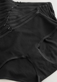 Black cotton underwear with a smooth texture, featuring decorative lace trim and small bows on the waistband. Multiple pieces layered.