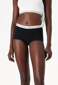 Sorte boxershorts med en hvid elastisk talje, der har "BJÖRN BORG" logo. Blødt, strækbart stof for komfort og pasform.