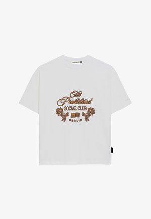 Biely bavlnený tričko s hnedou grafickou potlačou, na ktorej je nápis "The Prohibited Social Club" a motívy leva, klasický okrúhly výstrih a krátke rukávy.
