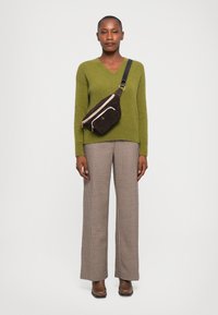 Knit olive green sweater with V-neck, brown plaid wide-leg pants, and a brown suede crossbody bag with zippers and adjustable strap.