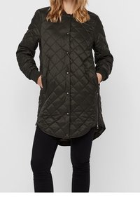 Giacca lunga trapuntata di colore verde scuro, con bottoni a pressione, tasche laterali, polsini a coste e orlo curvo per una silhouette moderna.