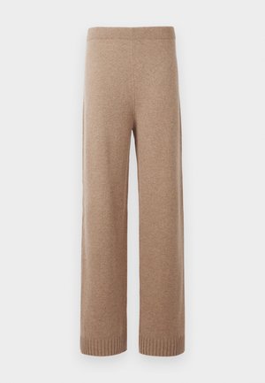Beige pletené kalhoty s širokými nohavicemi a vysokým pasem, s žebrovaným pasem a manžetami, vystavené na bílém pozadí.