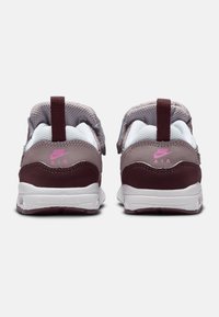 Nike Air boty s vínově červeným semišovým podpatkem, síťovinovým svrškem a růžovými akcenty na logu. Mají bílou mezipodešev a detailní textilní prvky.