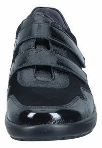Black athletic shoe featuring a combination of glossy and matte textures, with two adjustable Velcro straps and a cushioned sole.