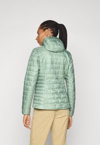 Lichtgroene pufferjack met capuchon, met een doorgestikte textuur en getailleerd ontwerp, gezien van achteren.