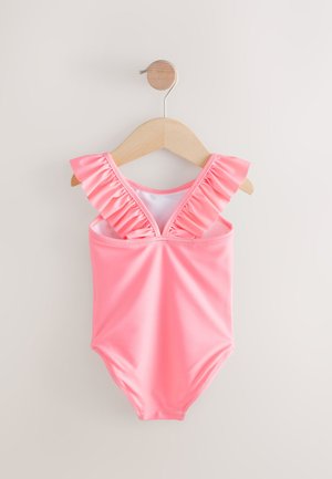 Maillot de bain une pièce rose avec bretelles volantées, fabriqué en tissu lisse et extensible. Dispose d'un décolleté en V et est suspendu à un cintre en bois.