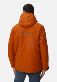 Pomarańczowa kurtka ocieplana z kapturem, z odblaskowym paskiem z tyłu, bezszwowym ramieniem i regulowanymi mankietami.