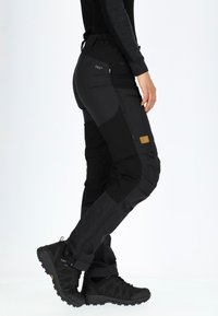 Zwarte outdoorbanden met een slim fit, met ritszakken, elastische tailleband en versterkte panelen op de knieën en dijen.