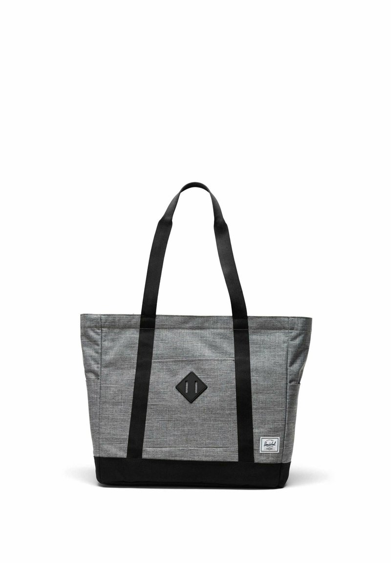 Sac fourre-tout gris et noir avec de longues poignées noires, un patch en forme de losange à l'avant et une petite étiquette de marque blanche dans le coin inférieur droit.