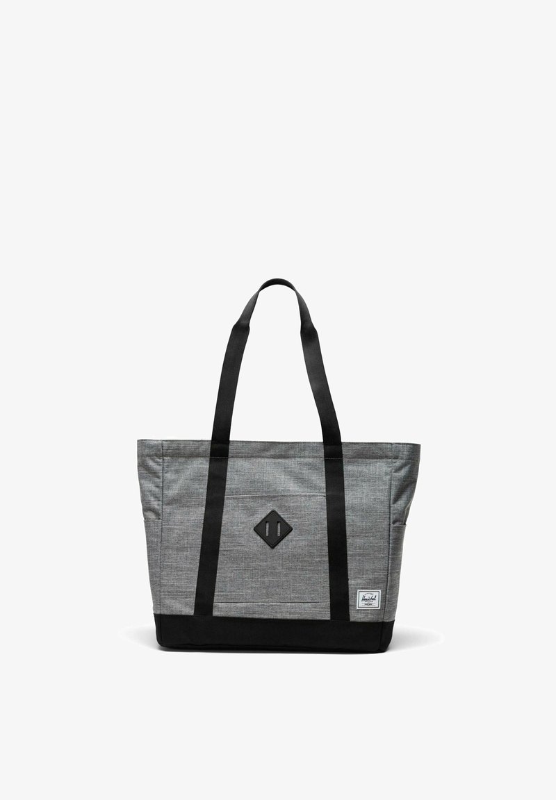 Sac fourre-tout gris et noir avec de longues poignées noires, un patch en forme de losange à l'avant et une petite étiquette de marque blanche dans le coin inférieur droit.