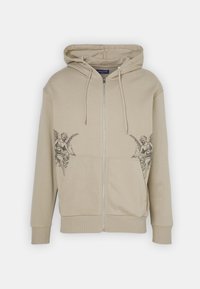 Beige Kapuzenpullover mit Reißverschluss aus Baumwollmischung und vorderen Taschen. Verziert mit schwarzen Engelmotiven auf beiden Seiten der Brust.