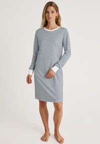 Vestito da notte a maniche lunghe a righe in bianco e blu navy. Tessuto morbido, collo a giro, e polsini a contrasto. Design di lunghezza media, vestibilità rilassata.
