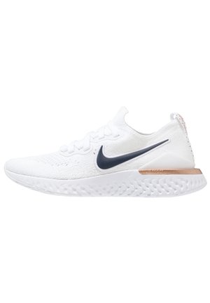 Hvid Nike løbesko med sort swoosh-logo, hvid tekstureret sål og roseguld accenter på hælen, set fra siden.