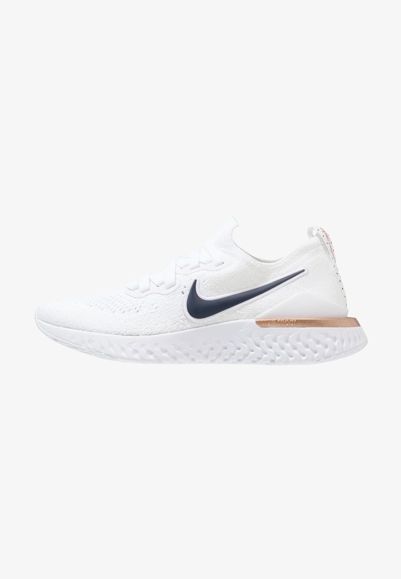 Chaussure de running Nike blanche avec logo swoosh noir, semelle blanche texturée et accent en or rose au talon, vue de côté.