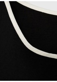 Czarna tkanina z białym wykończeniem, z okrągłym dekoltem. Tekstura wydaje się gładka; materiał jest lekki i miękki.