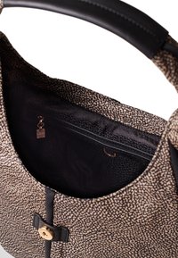 Black and beige patterned handbag with a smooth leather handle, interior zipper pocket, and a gold-tone decorative button closure.