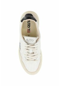 Sneaker bianca in pelle con punta perforata, dettagli beige e tallone nero. Presenta lacci scuri e un logo "AUTRY" sulla linguetta.
