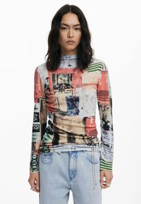 Top a maniche lunghe con un collage di motivi multicolori, caratterizzato da tonalità di rosa, blu e verde; tessuto morbido e elasticizzato; collo alto.