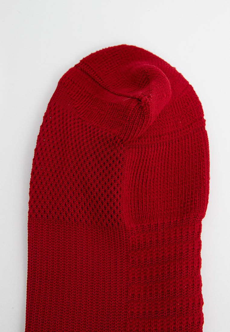 Calza rossa realizzata in tessuto a maglia testurizzata, con una punta liscia e un motivo a rete nella parte superiore per favorire la traspirabilità.