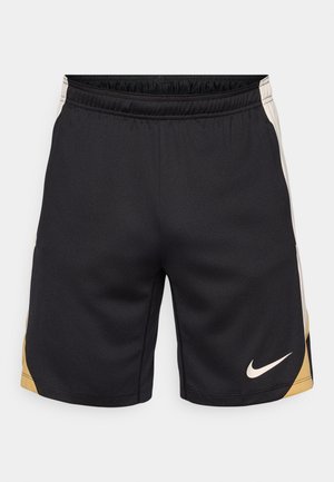 Pantaloni corti neri con una finitura texturizzata, caratterizzati da un accento dorato sul lato sinistro e un logo Nike ricamato di colore bianco in basso a destra.