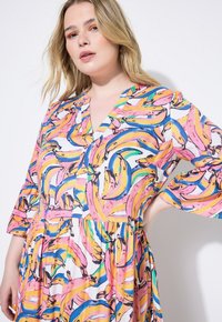 Bunt gefärbtes Kleid mit Bananendruck in Pink-, Gelb- und Blautönen, gestaltet mit einem V-Ausschnitt und drei Viertelärmeln.