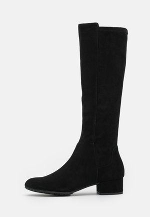 Bottes en suede noir jusqu'au genou avec un bout arrondi, un talon épais et un design sans coutures. Surface texturée avec des détails de couture minimalistes.