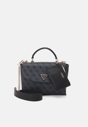 Sac à main noir Guess avec une petite pochette assortie attachée, quincaillerie dorée, poignée supérieure et bandoulière amovible sur un fond uni.