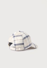 Ρυθμιζόμενο καπέλο μπέιζμπολ με καρό μοτίβο σε μπεζ, λευκό και μπλε, με μεταλλικό λουράκι με αγκράφα στο πίσω μέρος, σε λευκό φόντο.